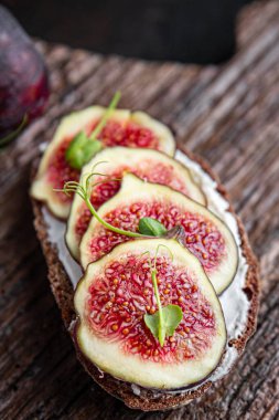 İncirli sandviç, krem peynirli sağlıklı kahvaltı taze porsiyon yemek için hazır yemek fotokopisi arka plan kırsalında. Top view keto ya da paleo diyet vejetaryen ya da vejetaryen yemekleri