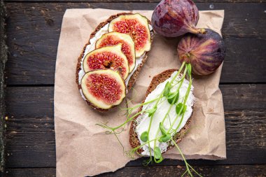 İncirli sandviç, krem peynirli sağlıklı kahvaltı taze porsiyon yemek için hazır yemek fotokopisi arka plan kırsalında. Top view keto ya da paleo diyet vejetaryen ya da vejetaryen yemekleri
