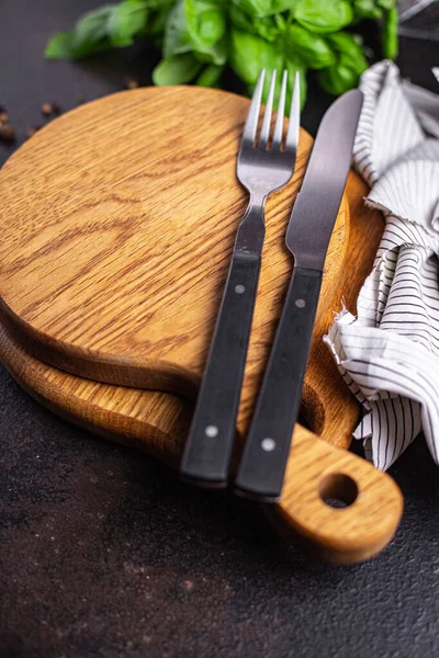 wooden serving board and cutlery fork and knife zero waste meal on the table copy space food background rustic. top view