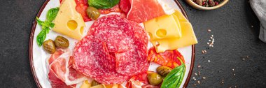 Atıştırmalık et, sosis, peynir, jambon, zeytin taze porsiyon yemek aperatiflerini yemek için masa arkasında hazır yemek arka planı kırsalında. en üstteki görünüm