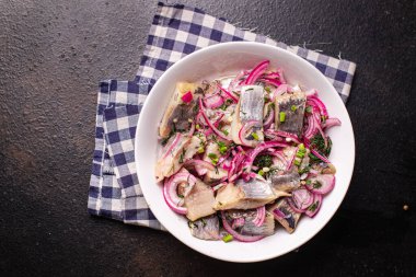 Ringa dilimi soğan salamurası tuzlu balık deniz ürünleri. Masanın üzerinde taze yiyecek fotokopisi. Arka plan, kırsal pezetarya diyeti.