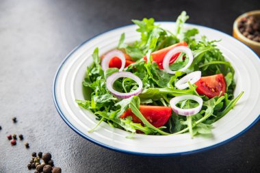Arugula ve domates salatası taze bir porsiyonda hazır yemek atıştırmalığı için fotokopi uzayı arka plan kırsalında. Top view keto ya da paleo diyet vejetaryen ya da vejetaryen yemekleri