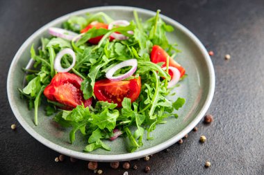 Arugula ve domates salatası taze bir porsiyonda hazır yemek atıştırmalığı için fotokopi uzayı arka plan kırsalında. Top view keto ya da paleo diyet vejetaryen ya da vejetaryen yemekleri