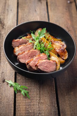 ördek göğsü eti ve süslemeli kümes hayvanları. Masanın arkasında taze yemek atıştırmalığı.