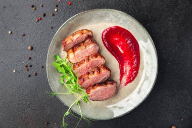 ördek göğsü eti ve süslemeli kümes hayvanları. Masanın arkasında taze yemek atıştırmalığı.