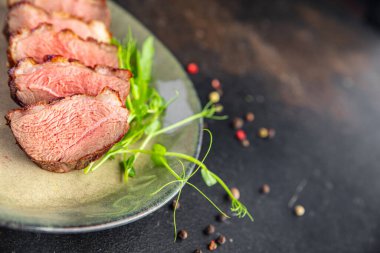 ördek göğsü eti ve süslemeli kümes hayvanları. Masanın arkasında taze yemek atıştırmalığı.