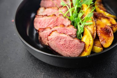 ördek göğsü eti ve süslemeli kümes hayvanları. Masanın arkasında taze yemek atıştırmalığı.