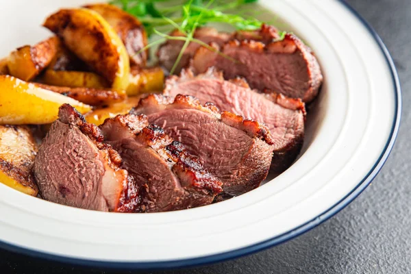 ördek göğsü eti ve süslemeli kümes hayvanları. Masanın arkasında taze yemek atıştırmalığı.