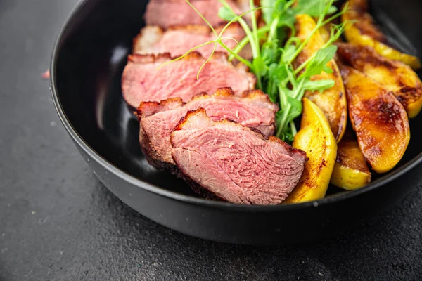 ördek göğsü eti ve süslemeli kümes hayvanları. Masanın arkasında taze yemek atıştırmalığı.