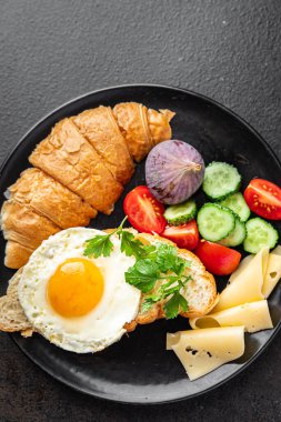 Kızarmış yumurta kahvaltı fincanı. Sıvı yumurta sarısı. Masada taze yemek. 