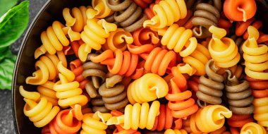 makarna trottole üç renkli makarna sarmalı bükülmüş İtalyan yemeği lezzetli çerez lezzetli gurme yemek arkaplan masa üzerinde rustik üst görünüm fotokopi alanı vegan ve vejetaryen gıda