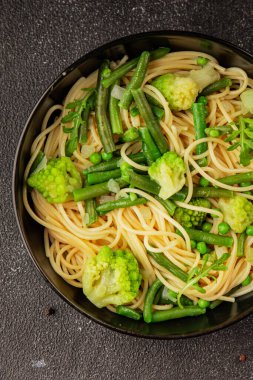 Spagetti sebzesi, bezelye, brokoli, çalı fasulyesi, kohlrabi vejetaryen makarna lezzetli makarna masanın üzerinde taze lezzetli gurme yemek.