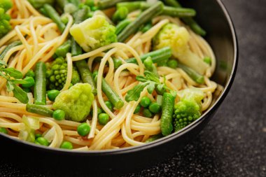 Spagetti sebzesi, bezelye, brokoli, çalı fasulyesi, kohlrabi vejetaryen makarna lezzetli makarna masanın üzerinde taze lezzetli gurme yemek.