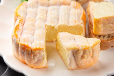 Yıkanmış kabuklu peynir portakal kabuklu yumuşak peynir Fransız peyniri lezzetli aperatif lezzetli gurme yemek arkaplanı masanın kırsal kesiminde fotokopi alanı.