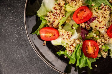 Kinoa salatası domates, yeşil yaprak salatası sebzeler... doğal ürün... lezzetli çerez... lezzetli gurme yemek... masanın üstünde... rustik üst görünüm... fotokopi alanı keto... ve paleo diyet vegan ve vejetaryen yiyecekler.