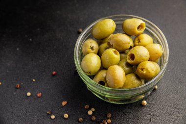 Yeşil zeytinler, çekirdeksiz doğal ürün turşusu. Lezzetli atıştırmalıklar. Lezzetli gurme yemek arkaplanı.