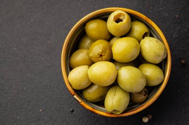 Yeşil zeytinler, çekirdeksiz doğal ürün turşusu. Lezzetli atıştırmalıklar. Lezzetli gurme yemek arkaplanı.