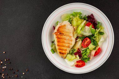 Izgara tavuk göğsü salatası tavuk göğsü domates, yeşil yaprak marul, salata karışımı sebze lezzetli çerez lezzetli gurme yemek arka planı masa rustik üst görünüm fotokopi alanı keto ve paleo diyeti