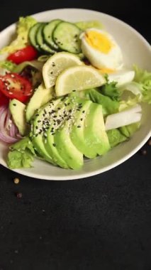 Avokado salata yumurtası, domates, soğan, yeşil yaprak salatası sebze, doğal çerez, lezzetli çerez, lezzetli gurme yemek arka planı, masa rustik üst görünüm fotokopi alanı keto ve paleo diyet vegan ve vejetaryen yemekleri.