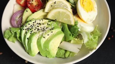 Avokado salata yumurtası, domates, soğan, yeşil yaprak salatası sebze, doğal çerez, lezzetli çerez, lezzetli gurme yemek arka planı, masa rustik üst görünüm fotokopi alanı keto ve paleo diyet vegan ve vejetaryen yemekleri.