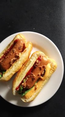 Sosisli kızartılmış soğan, sosis, çörek, fast food lezzetli çerez lezzetli gurme yemek arka planı masanın kırsal kesiminde fotokopi alanı.