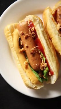 Sosisli kızartılmış soğan, sosis, çörek, fast food lezzetli çerez lezzetli gurme yemek arka planı masanın kırsal kesiminde fotokopi alanı.