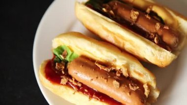 Sosisli kızartılmış soğan, sosis, çörek, fast food lezzetli çerez lezzetli gurme yemek arka planı masanın kırsal kesiminde fotokopi alanı.