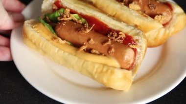 Sosisli kızartılmış soğan, sosis, çörek, fast food lezzetli çerez lezzetli gurme yemek arka planı masanın kırsal kesiminde fotokopi alanı.