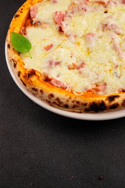 Pizza jambonu, peynir, domates sosu fast food doğal ürün lezzeti lezzetli gurme yemek arkaplanı masanın kırsal kesiminde fotokopi alanı.