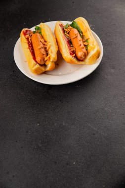 Sosisli kızartılmış soğan, sosis, çörek, fast food lezzetli çerez lezzetli gurme yemek arka planı masanın kırsal kesiminde fotokopi alanı.