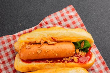 Sosisli kızartılmış soğan, sosis, çörek, fast food lezzetli çerez lezzetli gurme yemek arka planı masanın kırsal kesiminde fotokopi alanı.