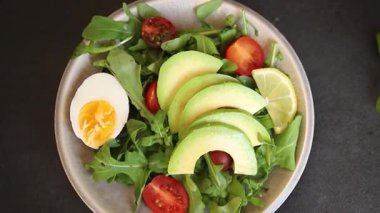 Avokado salatası roka, yumurta, domates, karışık yeşillikler, sebzeler taze gurme yemek arka plan lezzetli yemek masa üstü kırsal yemek fotokopi alanı keto ve paleo diyeti vejetaryen yemeği