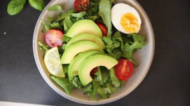 Avokado salatası roka, yumurta, domates, karışık yeşillikler, sebzeler taze gurme yemek arka plan lezzetli yemek masa üstü kırsal yemek fotokopi alanı keto ve paleo diyeti vejetaryen yemeği