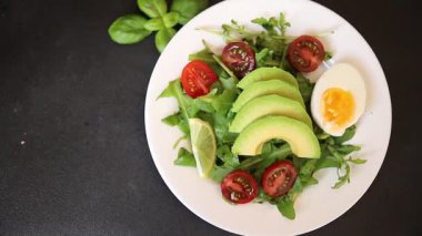 Avokado salatası roka, yumurta, domates, karışık yeşillikler, sebzeler taze gurme yemek arka plan lezzetli yemek masa üstü kırsal yemek fotokopi alanı keto ve paleo diyeti vejetaryen yemeği