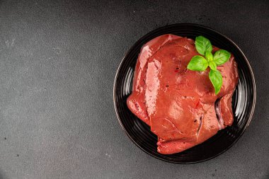 Karaciğer çiğ dana eti veya domuz eti sakatatı pişmiş doğal lezzetli aperatif taze lezzetli gurme yemek arkaplanı masa üzerinde rustik üst görünüm fotokopi alanı keto veya paleo diyeti