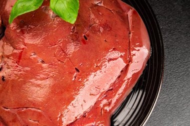 Karaciğer çiğ dana eti veya domuz eti sakatatı pişmiş doğal lezzetli aperatif taze lezzetli gurme yemek arkaplanı masa üzerinde rustik üst görünüm fotokopi alanı keto veya paleo diyeti