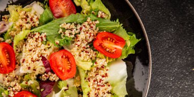 Kinoa salatası domates, yeşil yaprak salatası sebzeler... doğal ürün... lezzetli çerez... lezzetli gurme yemek... masanın üstünde... rustik üst görünüm... fotokopi alanı keto... ve paleo diyet vegan ve vejetaryen yiyecekler.