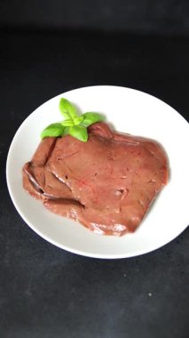 Karaciğer çiğ dana eti veya domuz eti sakatatı pişmiş doğal lezzetli aperatif taze lezzetli gurme yemek arkaplanı masa üzerinde rustik üst görünüm fotokopi alanı keto veya paleo diyeti