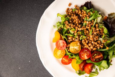 Mercimek salatası sebzeleri, domates, yeşil yaprak marul lezzetli aperatif lezzetli lezzetli gurme yemek masası kırsal üst görünüm fotokopi alanı keto ve paleo diyet vejetaryen ve vejetaryen yemekleri.