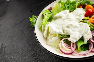 Burrata salatası domates, mor soğan, yeşil yaprak marul lezzetli aperatif taze gurme yemek masası kırsal yemek üst görünüm fotokopi alanı keto ve paleo diyet vejetaryen yemeği.