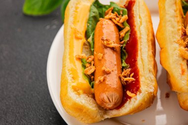 Sosisli kızartılmış soğan, sosis, çörek, fast food lezzetli çerez lezzetli gurme yemek arka planı masanın kırsal kesiminde fotokopi alanı.