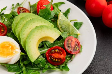 Avokado salatası roka, yumurta, domates, karışık yeşillikler, sebzeler taze gurme yemek arka plan lezzetli yemek masa üstü kırsal yemek fotokopi alanı keto ve paleo diyeti vejetaryen yemeği