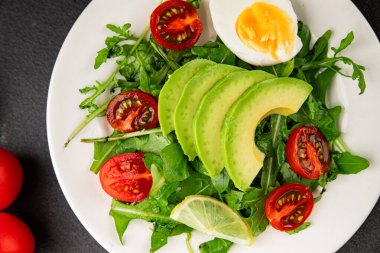 Avokado salatası roka, yumurta, domates, karışık yeşillikler, sebzeler taze gurme yemek arka plan lezzetli yemek masa üstü kırsal yemek fotokopi alanı keto ve paleo diyeti vejetaryen yemeği