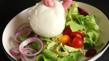 Burrata peyniri domates, mor soğan, yeşil yaprak marul lezzetli aperatif taze gurme yemek masası kırsal yiyeceklerin üst görünümü fotokopi alanı keto ve paleo diyet vejetaryen yemeği.