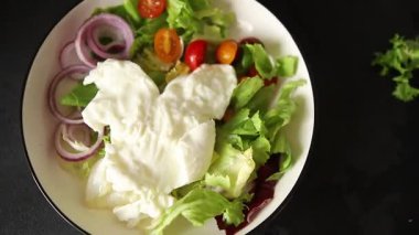 Burrata peyniri domates, mor soğan, yeşil yaprak marul lezzetli aperatif taze gurme yemek masası kırsal yiyeceklerin üst görünümü fotokopi alanı keto ve paleo diyet vejetaryen yemeği.