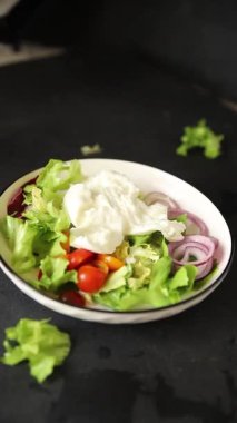Burrata peyniri domates, mor soğan, yeşil yaprak marul lezzetli aperatif taze gurme yemek masası kırsal yiyeceklerin üst görünümü fotokopi alanı keto ve paleo diyet vejetaryen yemeği.
