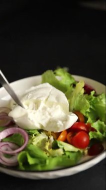 Burrata peyniri domates, mor soğan, yeşil yaprak marul lezzetli aperatif taze gurme yemek masası kırsal yiyeceklerin üst görünümü fotokopi alanı keto ve paleo diyet vejetaryen yemeği.