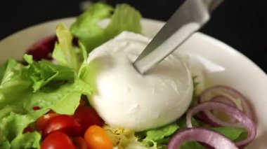 Burrata peyniri domates, mor soğan, yeşil yaprak marul lezzetli aperatif taze gurme yemek masası kırsal yiyeceklerin üst görünümü fotokopi alanı keto ve paleo diyet vejetaryen yemeği.