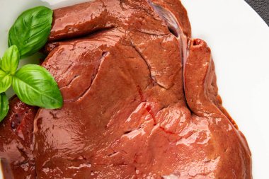 Karaciğer çiğ dana eti veya domuz eti sakatatı pişmiş doğal lezzetli aperatif taze lezzetli gurme yemek arkaplanı masa üzerinde rustik üst görünüm fotokopi alanı keto veya paleo diyeti