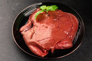 Karaciğer çiğ dana eti veya domuz eti sakatatı pişmiş doğal lezzetli aperatif taze lezzetli gurme yemek arkaplanı masa üzerinde rustik üst görünüm fotokopi alanı keto veya paleo diyeti